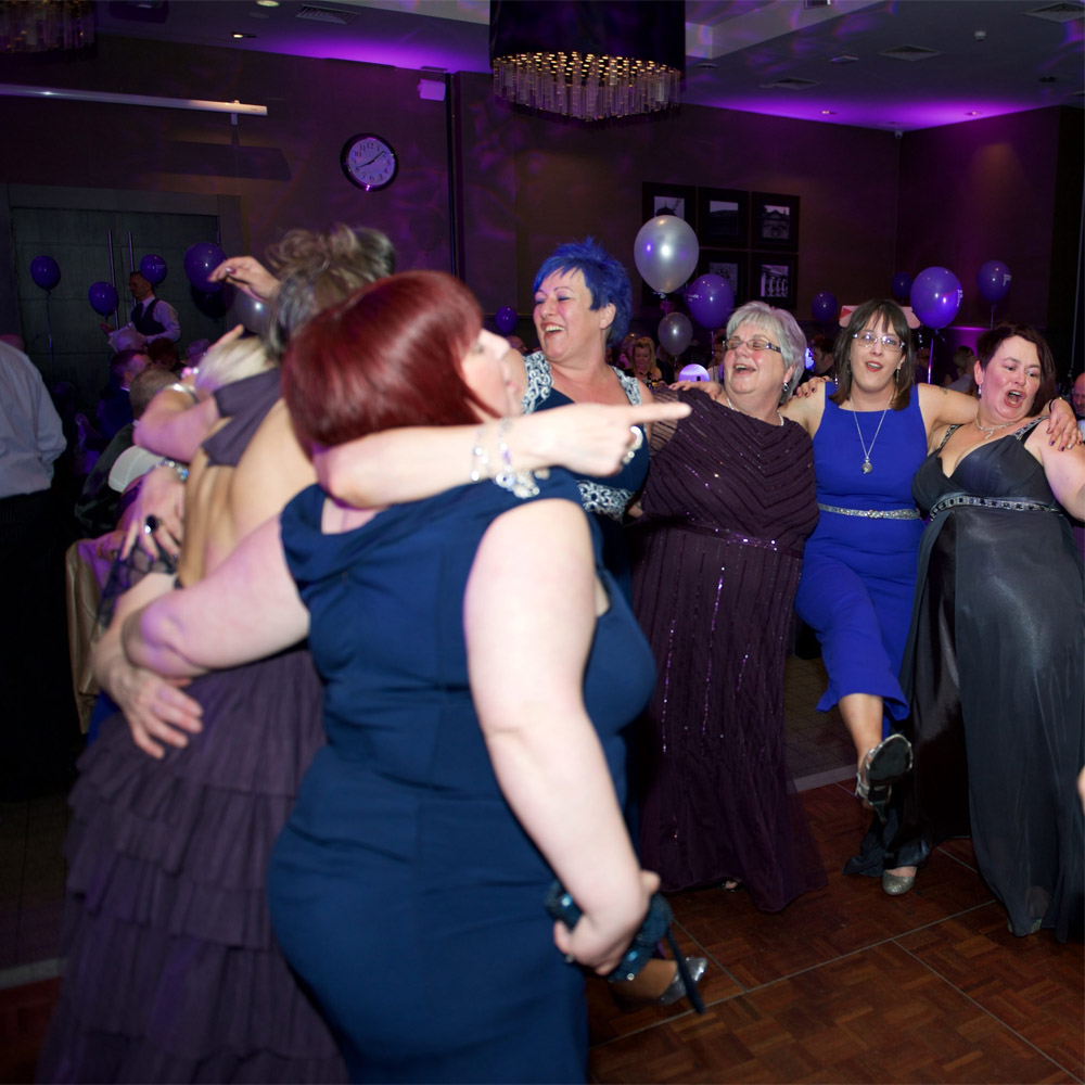 Evening wedding reception with coloured uplighting around the room