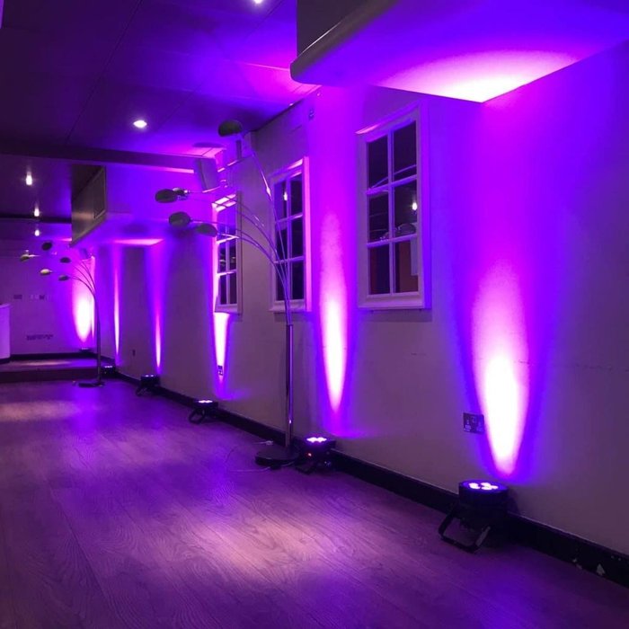Purple wireless uplighting around a function room wall
