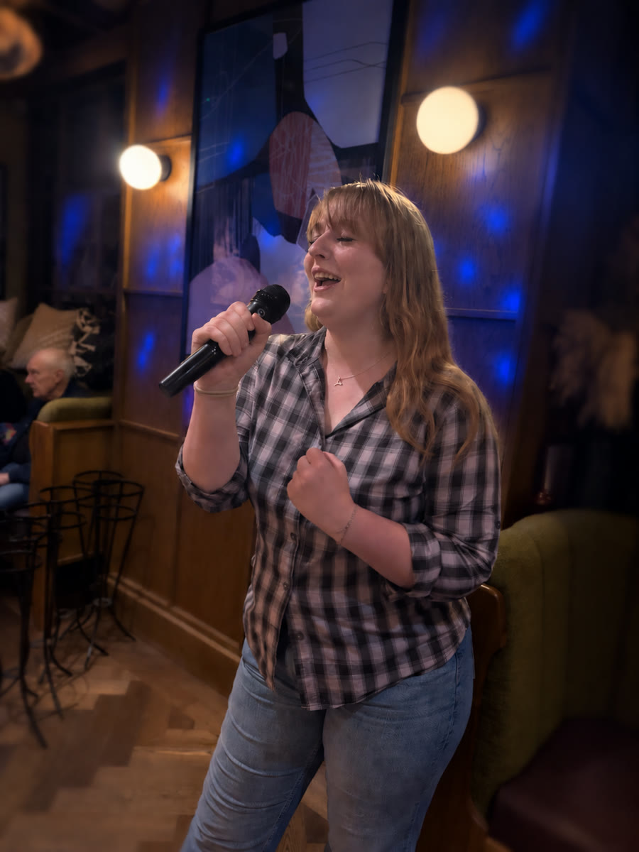Woman singing into a microphone during a karaoke performance