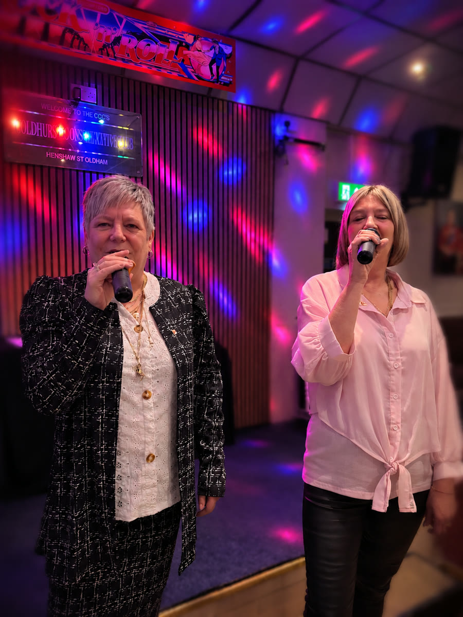 Two women singing together at a karaoke night