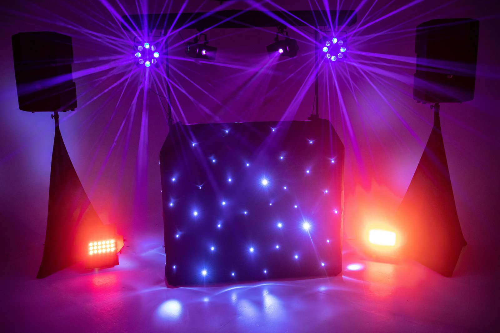 DJ booth, speakers and lighting creating a purple party setup
