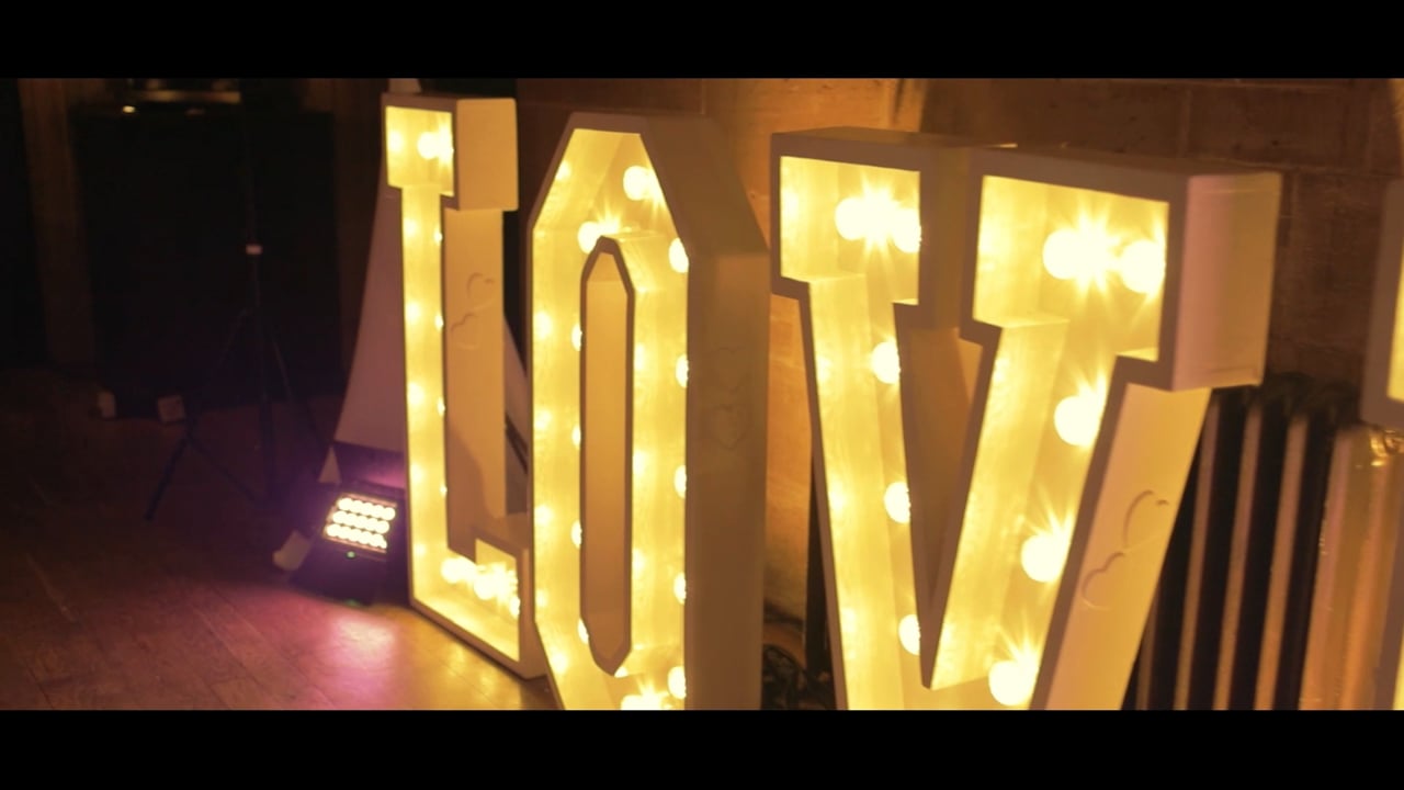 Guests dancing under warm lighting at a barn wedding reception