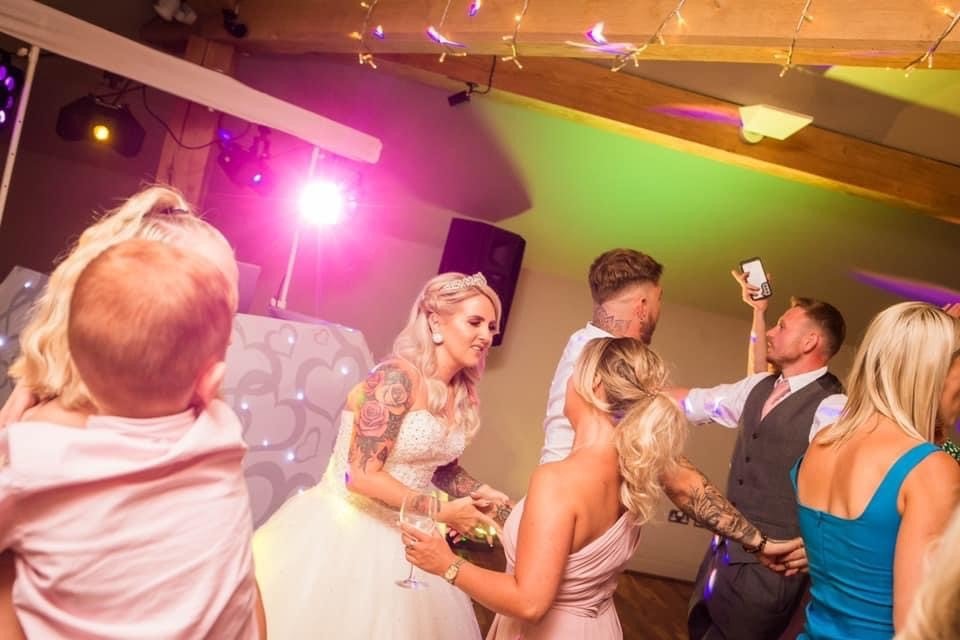 Bride dancing with wedding guests on a lit-up dancefloor