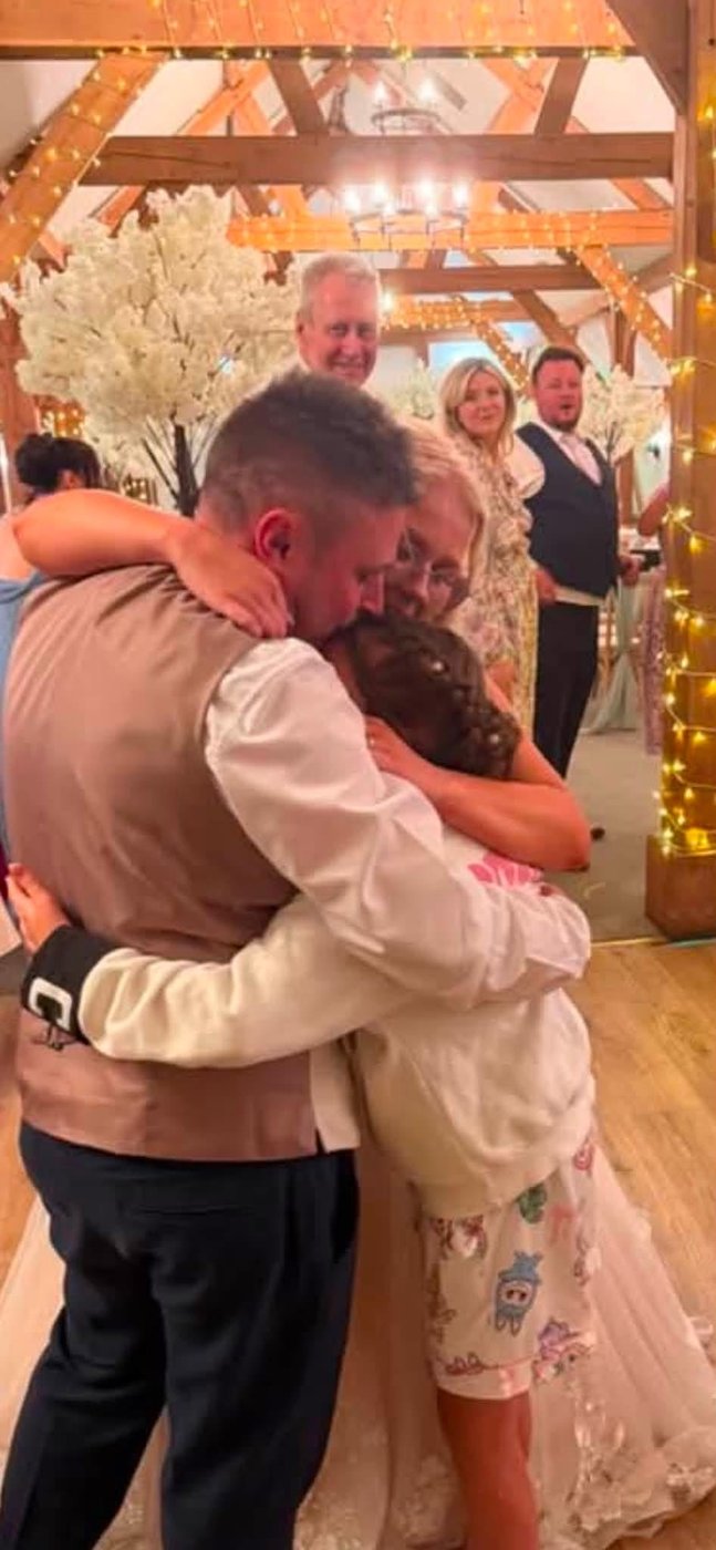 Groom sharing a family hug on the dancefloor