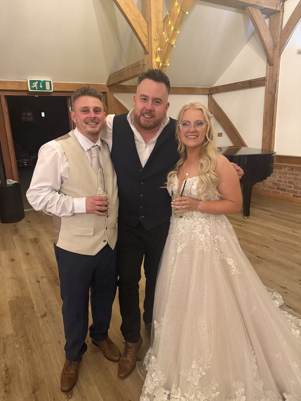 Andy Flash with a bride and groom at a rustic wedding venue